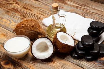 Oil, coconut and stones for a massage on  wooden background