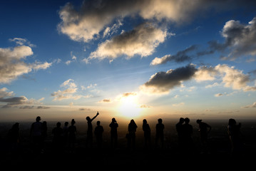  Silhouettes of tourist on the cliff when sunset at Korhong Hill in Hat Yai Thailand.