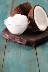 coconut oil and fresh coconuts on old wooden table