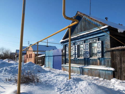 The blue wooden house and yellow gas tubes in the Russian town