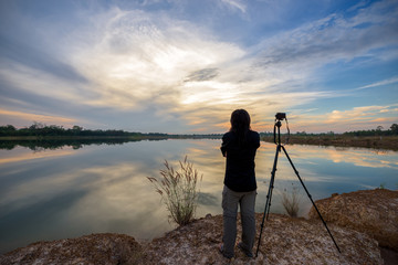 Photographer is taking a picture of landscape sunset.