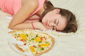 Obraz na płótnie Canvas fun sad overeat girl lying with pizza pieces