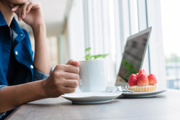 Woman working at home office hand holding coffee cup close up