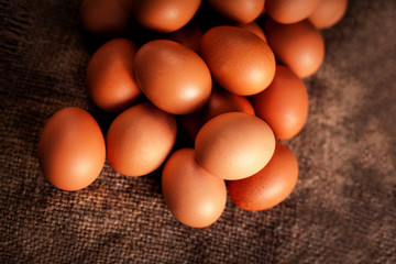 Eggs on wooden brown colored background closeup.