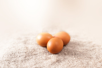 Eggs on wooden brown colored background closeup.