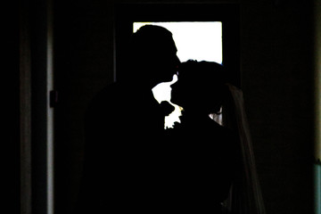 silhouette of young couple in love against the window
