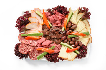Food tray with delicious salami, pieces of sliced ham, sausage, tomatoes, salad and vegetable - Meat platter with selection - Cutting sausage and cured meat on a celebratory table...