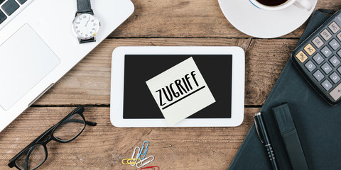 Naklejka premium Zugriff, German text for Access , yellow sticky note, office desk with computer technology, high angle