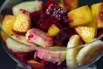 fruit salad on dark background, peaches, banana, dragon fruit
