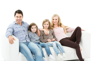 Happy family sitting on the sofa at home isolated.