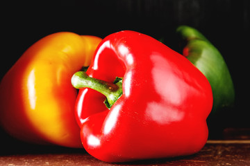 Fresh sweet vegetables Red, Yellow, Green Peppers. Dark backgrou