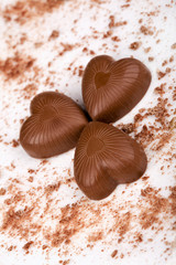 Three chocolate hearts on white background