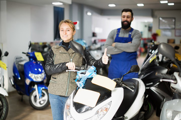 Fototapeta na wymiar Worker with woman customer in motorcycle workplace