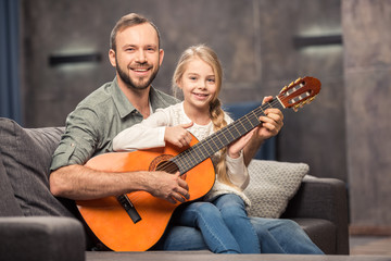 Father and daughter playing guitar