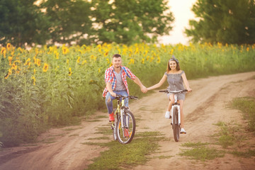 Young couple  on bicycles in the field