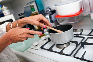 Cropped image of senior woman cooking at kitchen counter
