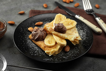 Delicious pancakes with banana and chocolate on plate