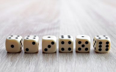 Dices on a wooden desk. Gambling devices.
