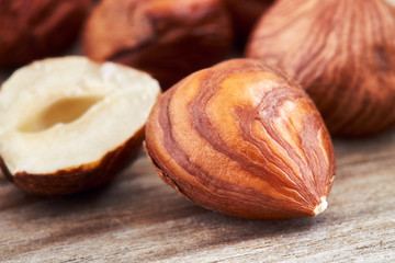 Peeled hazelnuts on wooden background, close-up with selective focus