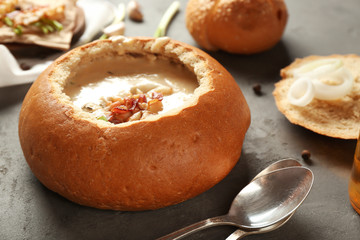 Delicious cream soup in bread on table