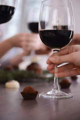 Female hand holding glass of red wine closeup