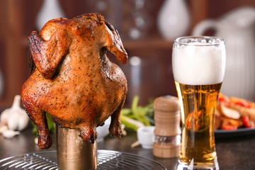 Grilled beer can chicken on kitchen table © Africa Studio