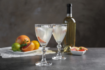 Glasses with delicious wine spritzer on grey table