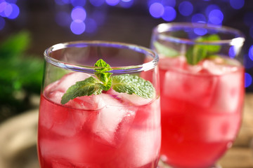Glass of delicious wine spritzer on blurred lights background