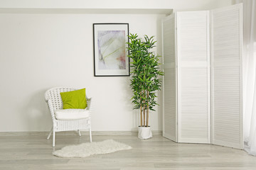 Interior of beautiful room with folding screen and armchair