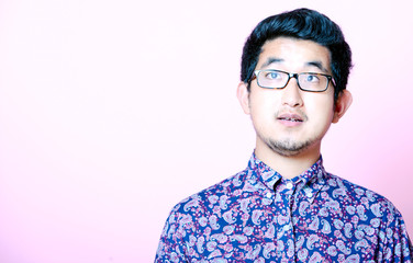 Fototapeta premium Young Geeky Asian Man in colorful shirt wearing glasses