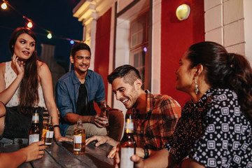 Friends sitting around a table at rooftop party
