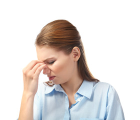 Beautiful young woman suffering from headache on white background