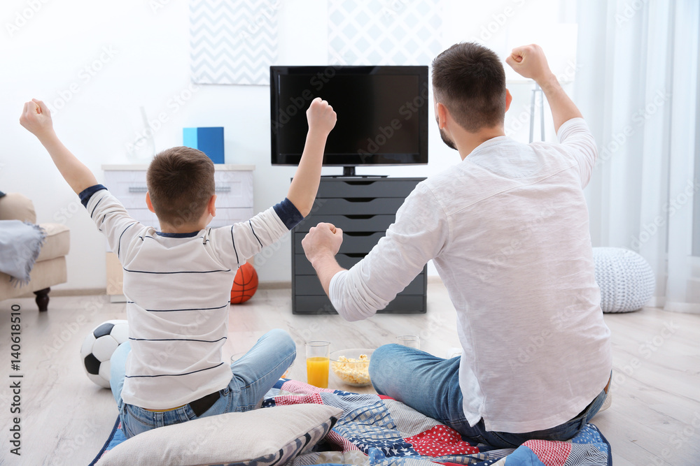 Canvas Prints Father and son watching football on TV at home