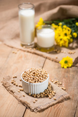 Soy milk or soya milk and soy beans on wooden table.