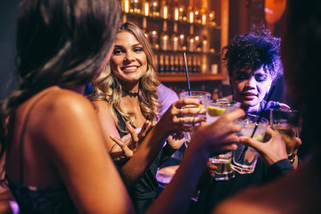 Group of friends having drinks at night club - obrazy, fototapety, plakaty