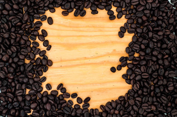 Roasted coffee beans frame spelled on wooden surface