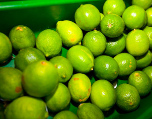 Close-up of green lemons on display in grocery store