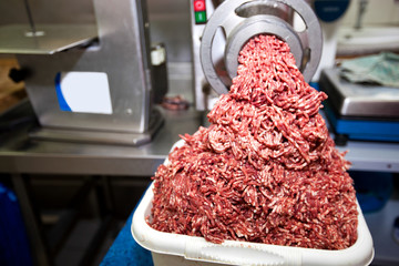 Machine mincing meat in grocery store