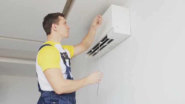 serviceman inspects and measures a air conditioning