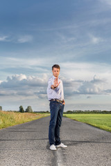 Portrait of serious young man making stop gesture at country road
