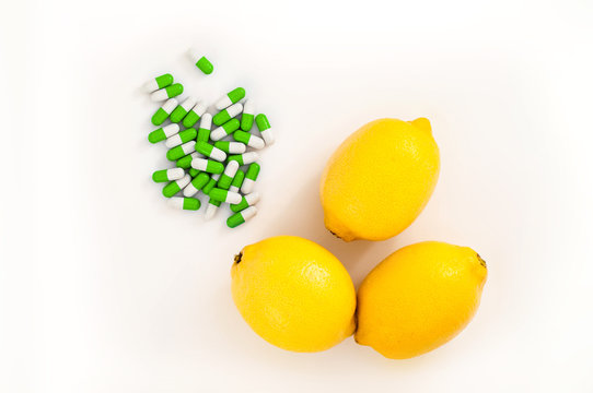 Three yellow lemons near medical pills as concept of healthy and alternative food