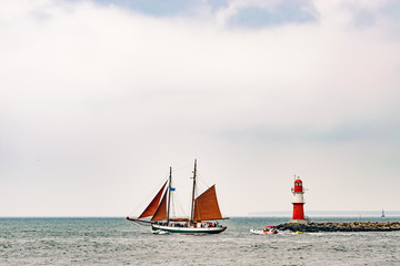 Naklejka premium Sailing ships on the sea. Tall Ship and lighthouse Yachting travel.