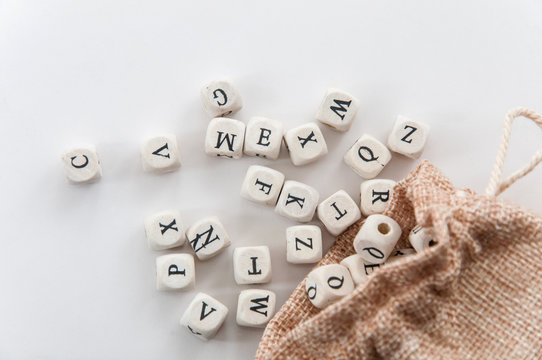 Few english letters on Dices fall off from burlap sack