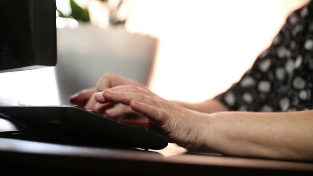 The woman types the text on the keyboard. Hands close up