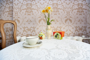 Coffee cup with vase on cafe table