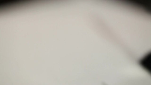 A stack of papers is stapled with a stapler