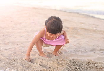 Portrait Kid girl playing sand at the beach