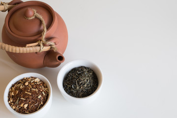 Tetera de barro con infusión de roiboos en taza blanca