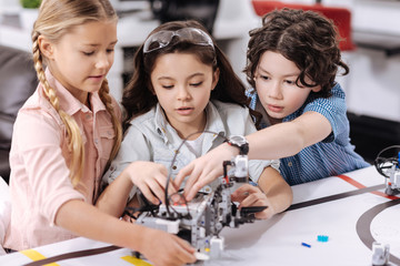 Busy young scientists discussing project at school