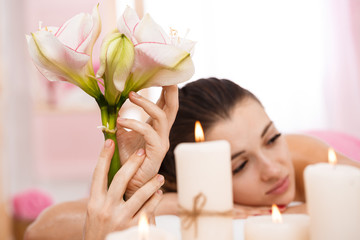 Closeup of young woman relaxing after back massage admiring atmosphere